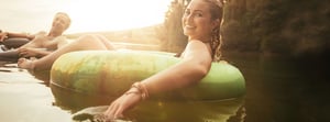two young adults tubing in a lake